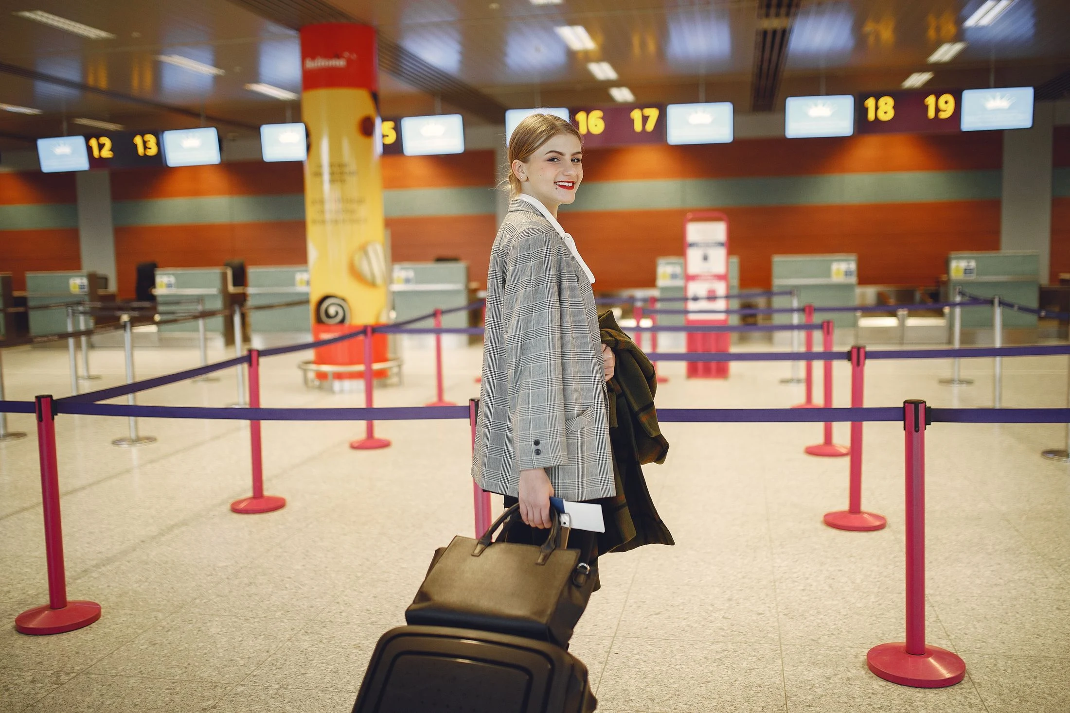 Traveller walking with a suitcase in an airport check-in area