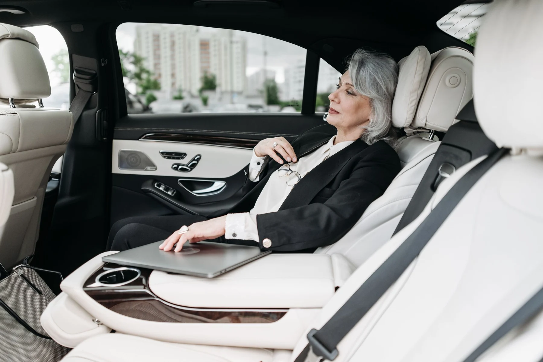 Executive traveller relaxing in the rear seat of a chauffeured car